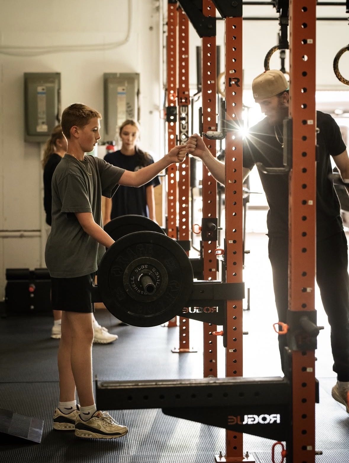 Coach celebrating with a young athlete after a lift at ETHOS