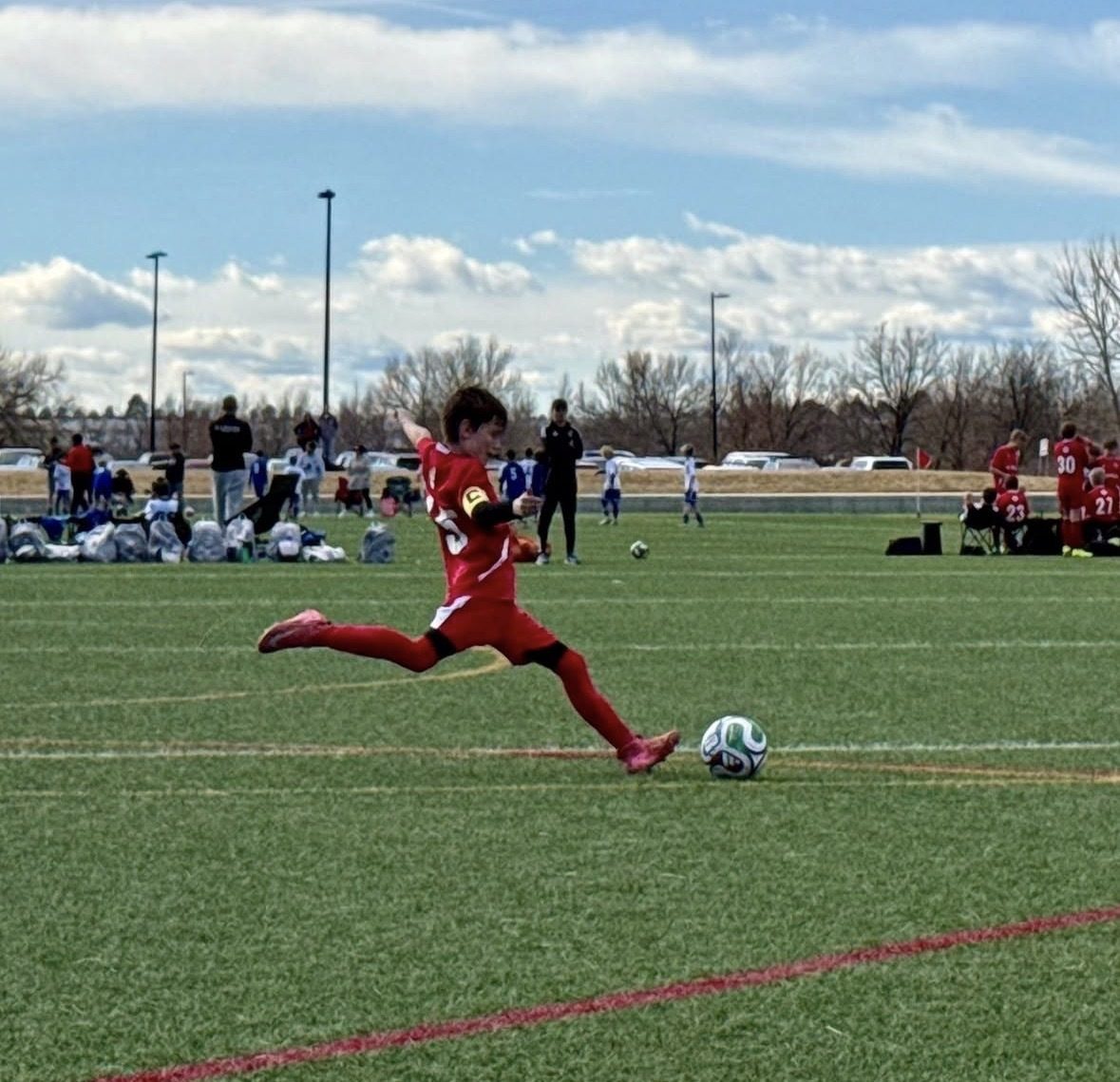 Youth soccer athlete striking the ball on a Colorado field